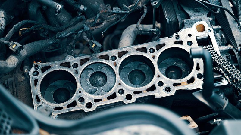 Car engine with visible piston and cylinder block, highlighting key internal engine components and structure.