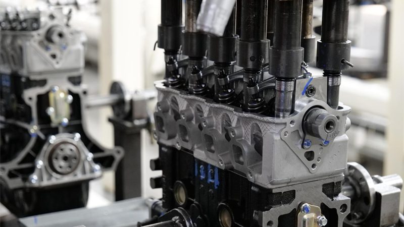 Automotive engine assembly process featuring advanced automation equipment in a modern manufacturing environment.