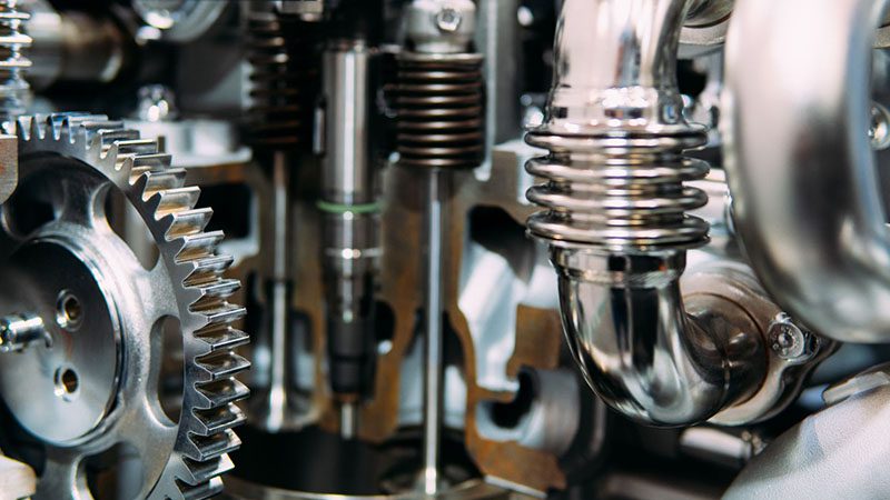 Internal view of truck diesel engine showing gears, wheels, and mechanical parts in detail.