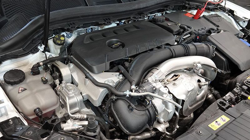 Detailed close-up of a turbocharged car engine, showcasing engine block, turbo system, and mechanical components.