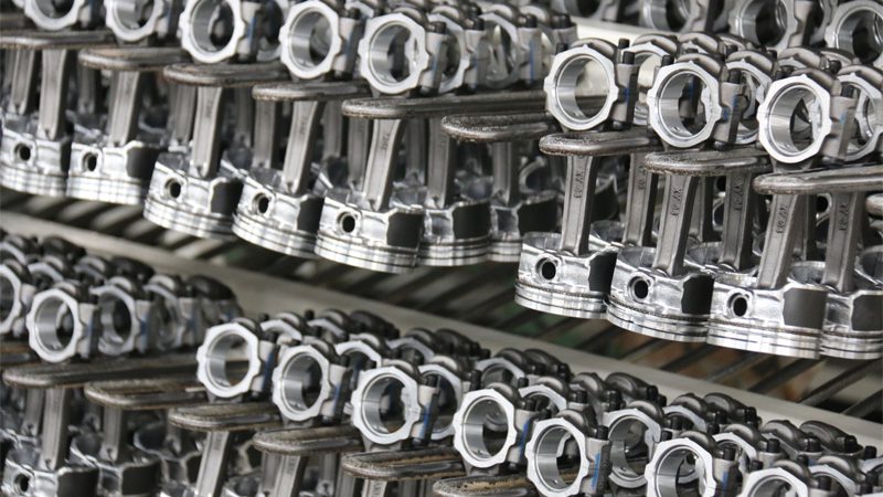 High-quality pistons displayed at Nanjing Woda Auto Technology Co., Ltd.'s factory, showcasing precision machining and detailed craftsmanship.