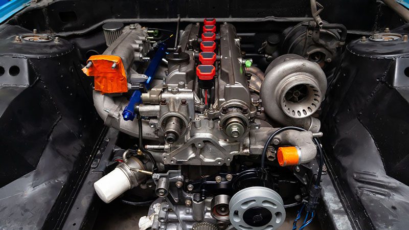 Close-up view of a car engine showing detailed components and mechanical parts.