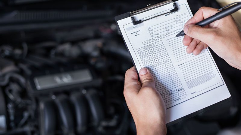 Mechanic inspecting car engine, diagnosing mechanical issues that can trigger limp mode.