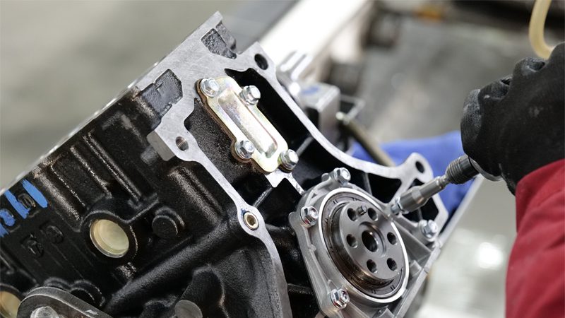 Engine being assembled on Nanjing Woda Auto Technology Co., Ltd production line, showcasing precision manufacturing of engine parts.