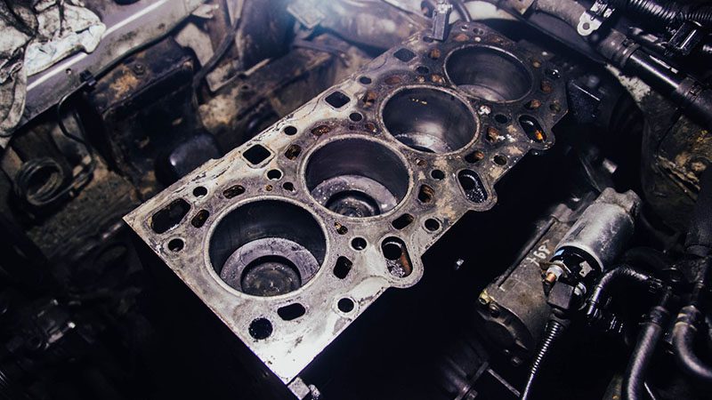 Close-up of a cylinder head with visible carbon deposits and buildup, highlighting the impact of poor combustion and lack of engine maintenance.