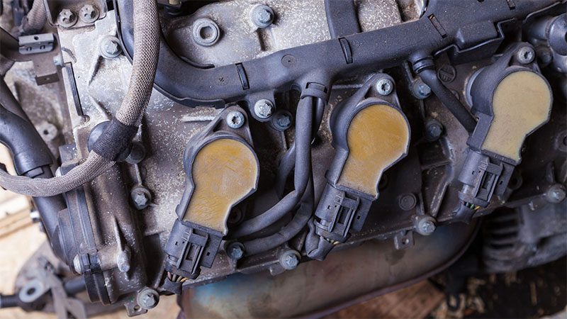 Close-up of an engine showing a potential faulty coil pack that may affect ignition performance.