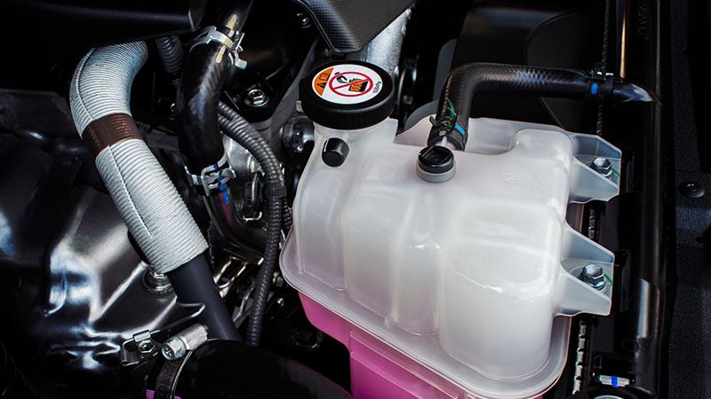 Coolant reservoir tank mounted on a car engine