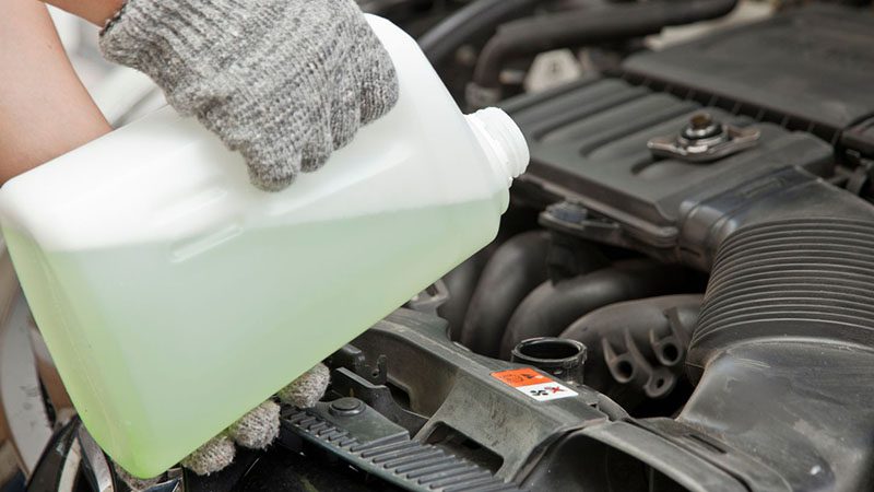 Adding coolant into a car engine to prevent overheating