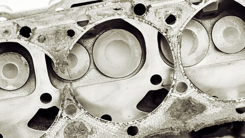 Close-up view of a cracked cylinder head showing visible damage to the metal surface.
