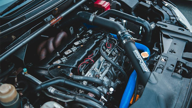 Close-up of a car engine showing the position of the crankshaft position sensor.