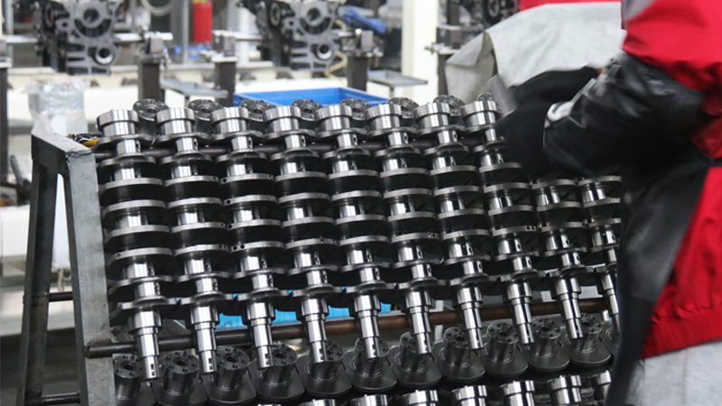 Crankshafts neatly arranged on factory shelves, showcasing a variety of high-quality automotive engine components ready for assembly.