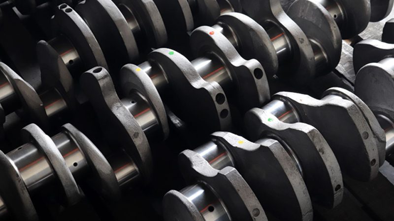 Close-up view of multiple car engine crankshafts on display, highlighting their structure and design for automotive use.