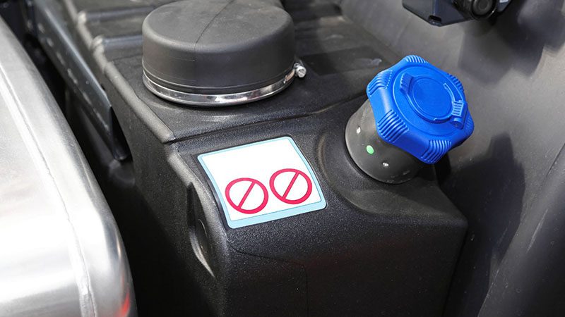 Close-up view of blue Diesel Exhaust Fluid (DEF) fill port on a vehicle