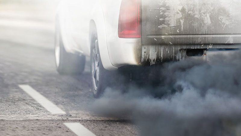 Black smoke emitting from a car’s exhaust, typically caused by incomplete diesel fuel combustion or air intake issues