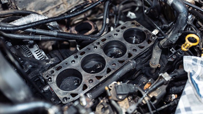 Repair of engine block and combustion chamber with cylinder block gasket replacement in progress.