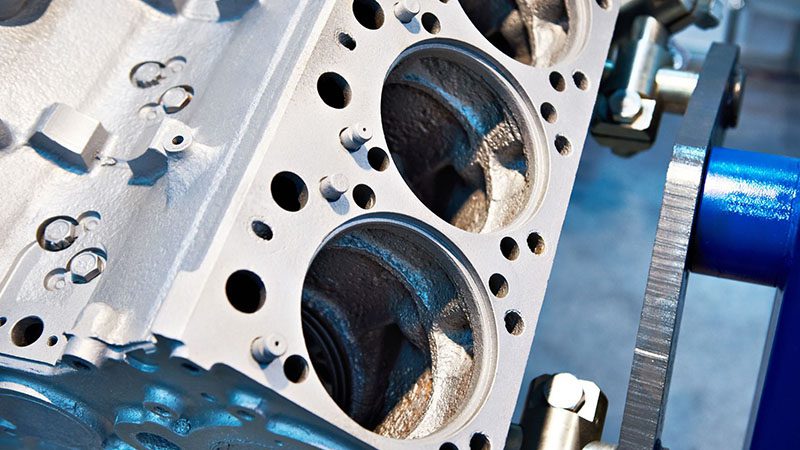 Engine block placed on a workbench in a mechanic's workshop.