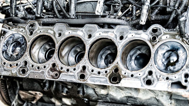 Close-up view of a car engine block showcasing cylinder bores and metal surface details.