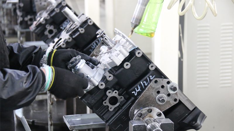 Engine production line at Nanjing Woda Auto Technology Co., Ltd. factory, with engines being assembled and tested.