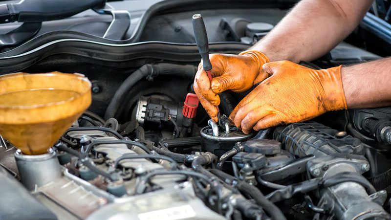 Mechanic carefully inspecting an engine to assess its condition and determine the necessary repairs for an overhaul.