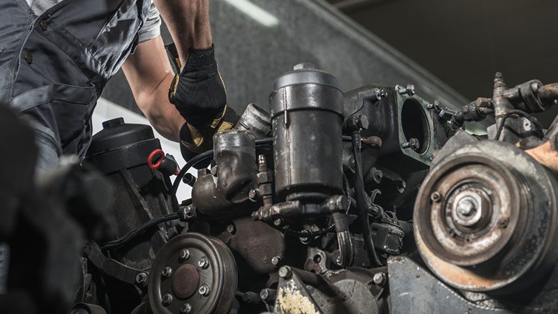 Mechanic working on a diesel engine overhaul, ensuring reliability and optimal performance.
