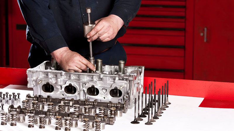 Close-up of a mechanic rebuilding an engine with precision tools in a workshop setting