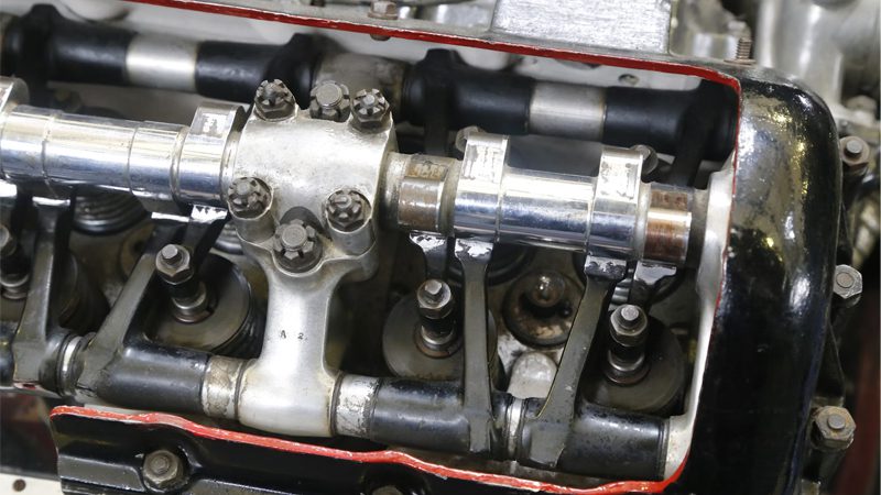Close-up view of engine valves seated in a cylinder head, showing detailed components and metal surface finish.