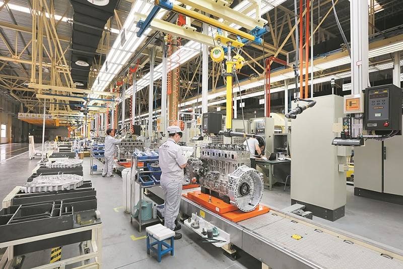 Wide view of the automobile engine parts factory, showcasing the production line, machinery, and assembly process.