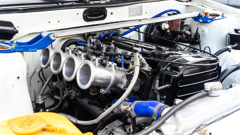Detailed view of a modified car engine with visible fuel injection components and performance upgrades.