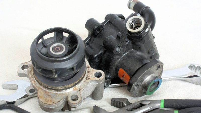 Close-up of a carburetor machine showing fuel mixing components and mechanical jets.