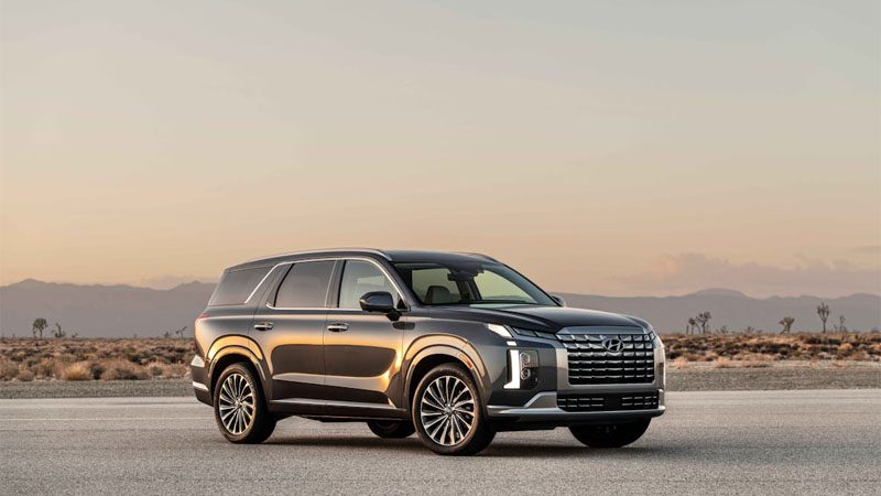 Sleek Hyundai SUV parked on an empty desert road at sunset with a scenic backdrop