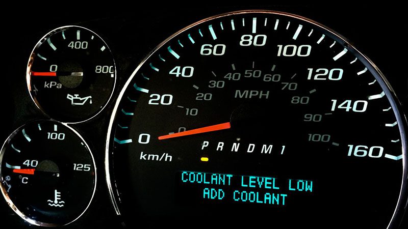 Dashboard coolant level low warning light illuminated in a car.