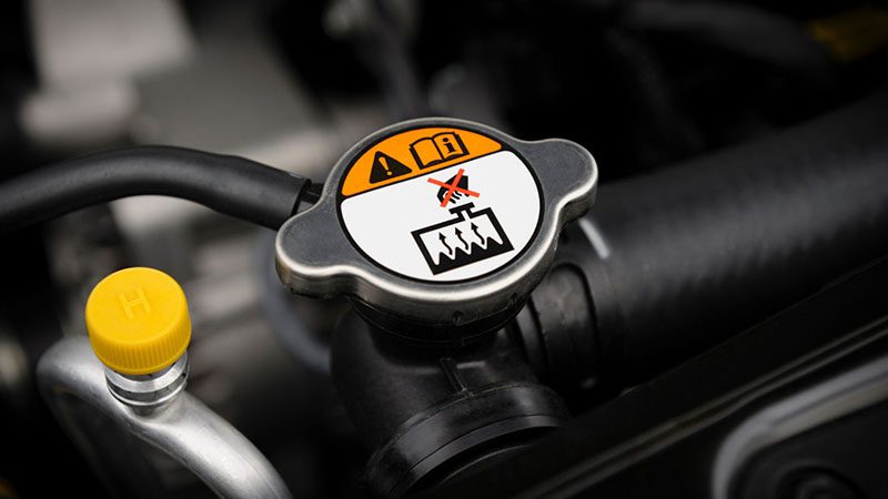Close-up of an engine coolant radiator cap on a car.