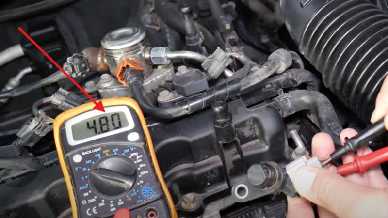Checking voltage by moving a metal object away from the camshaft position sensor.