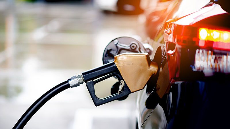 Fueling a tanker with a gas station nozzle, highlighting the process of refueling and fuel efficiency in action.