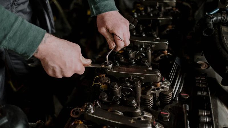 A mechanic's hands working on an engine, showcasing the precision and skill required for engine repair and maintenance.