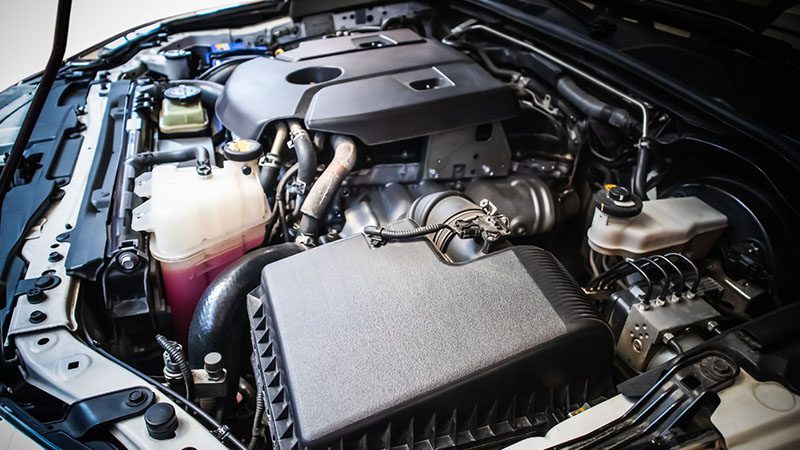 Close-up view of a 2.8-liter turbo diesel engine installed under the hood of a car, showing engine components and layout.