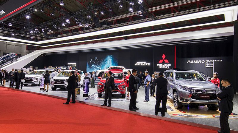 Mitsubishi booth at an automotive show featuring vehicle displays.