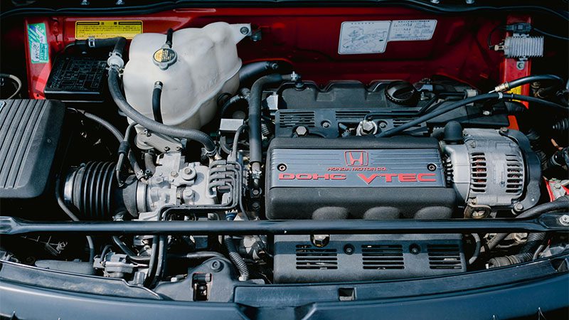 Close-up of a Honda DOHC VTEC engine inside a vehicle, showcasing components.