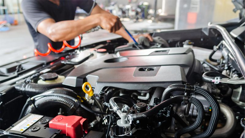 Mechanic cleaning a car engine after an engine wash