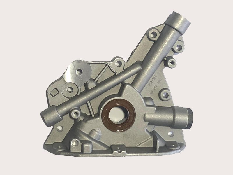 Close-up of a car engine oil pump, showing the gears, housing, and oil intake port.