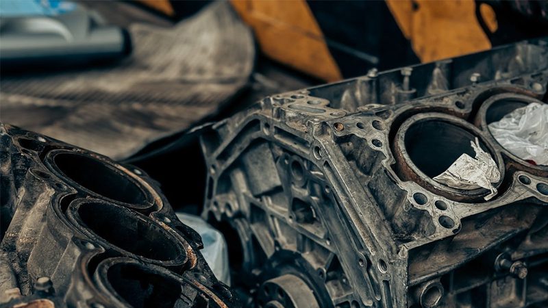Close-up of an old, cracked cylinder head in an engine, showing wear and damage over time.