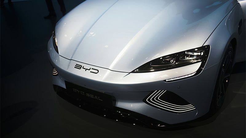 Close-up view of a BYD car front headlight and grille design, showcasing modern EV styling.