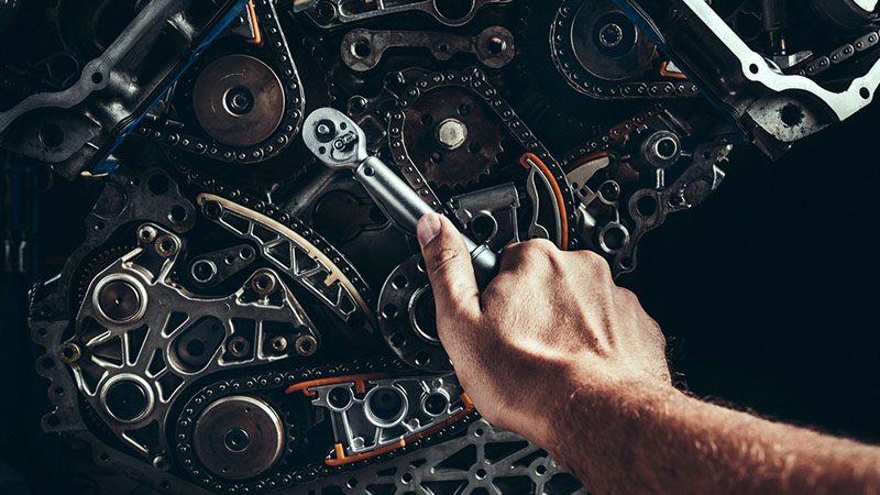 Car engine undergoing repair in a professional automotive workshop.