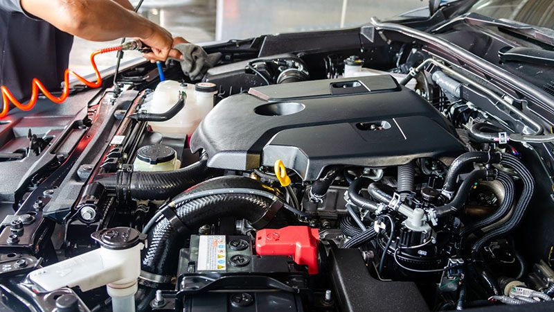 Mechanic performing regular engine maintenance in a professional workshop.