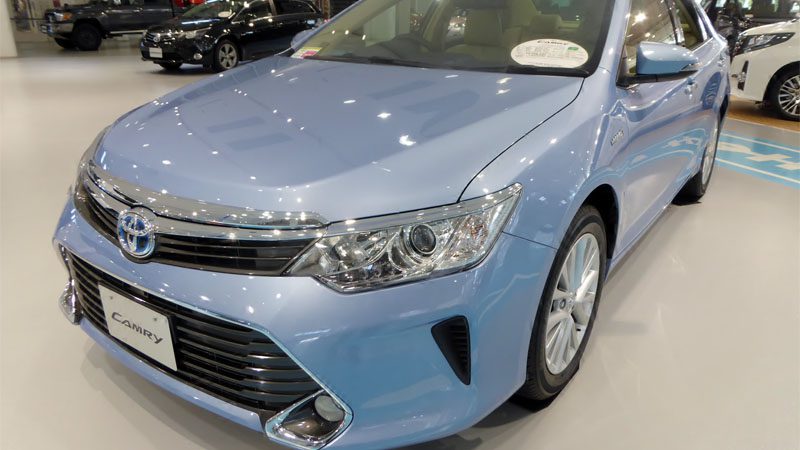 Close-up view of the Toyota Camry Hybrid, highlighting its sleek design and hybrid performance features.