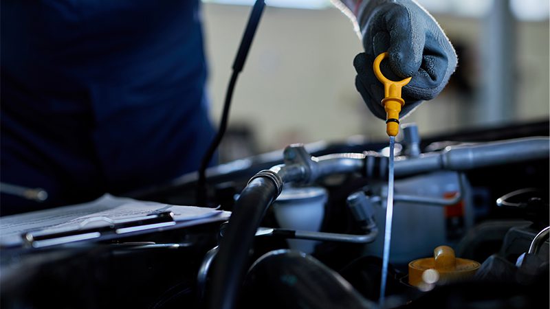 Mechanic performing a close-up inspection of a car engine to check for potential issues