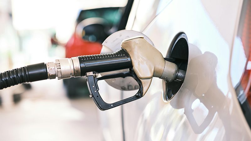 Fueling up a car at a gas station with a fuel nozzle.