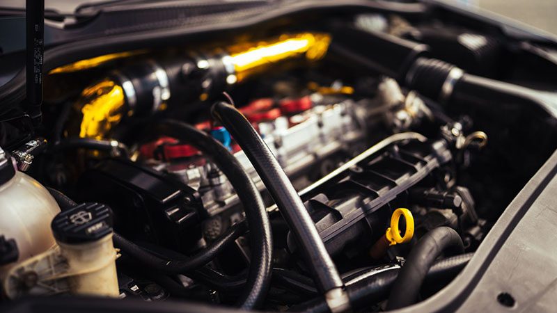 Close-up of a car engine, showing key components related to oiling systems and engine lubrication.