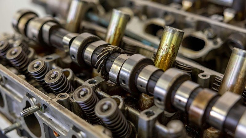 Close-up of camshaft and valves in an engine, essential components in the Variable Valve Timing (VVT) system for optimizing performance.