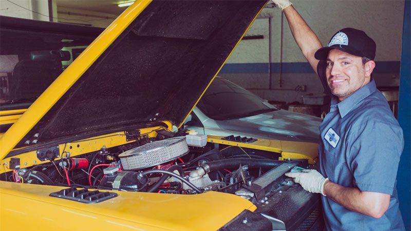 Mechanic working on an engine to resolve issues related to the P0300 code (random misfire).